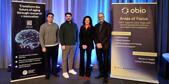 Four people standing on a backlit stage